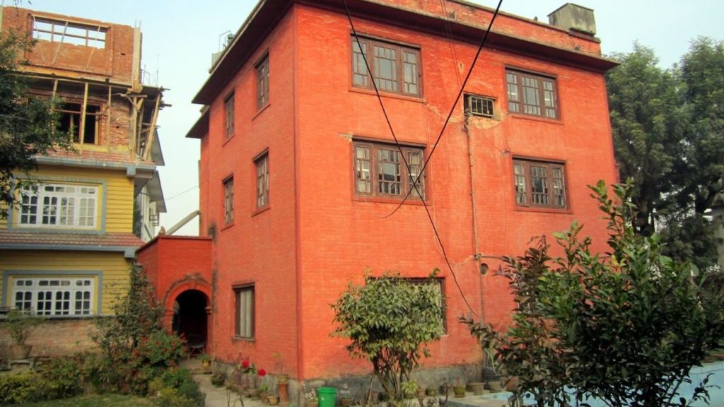 Red colored residential house in Kathmandu, representing buying homes in Kathmandu.